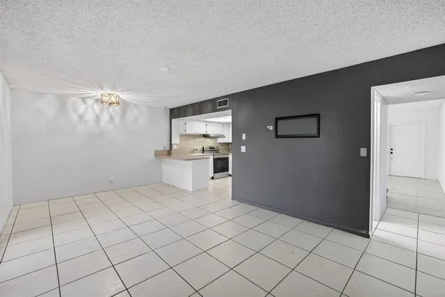 a large white kitchen with a sink and dishwasher a refrigerator with white cabinets