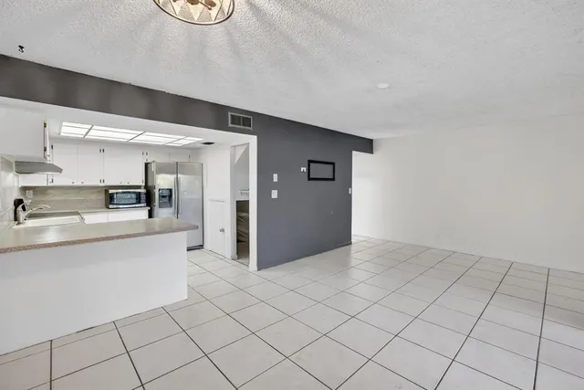 a kitchen with white cabinets and appliances