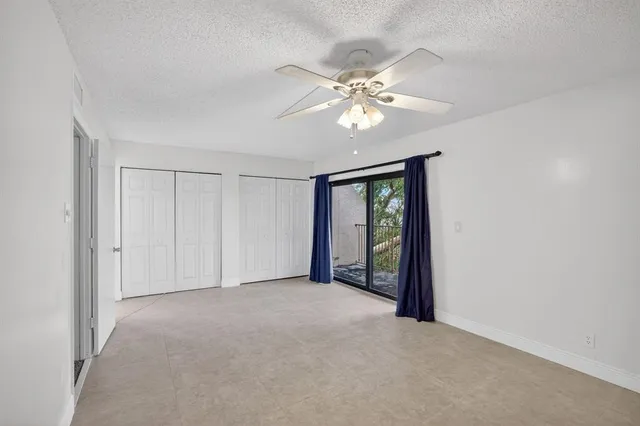 a view of an empty room with window and chandelier