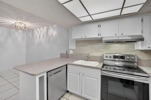 a view of a big room with wooden floor and windows