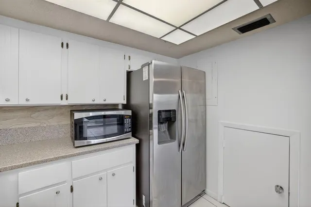 a view of an empty room with wooden floor and a ceiling fan