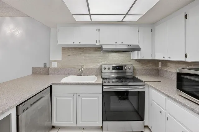 a view of a big room with wooden floor and windows