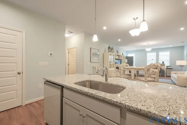 a kitchen with a sink a stove and chairs