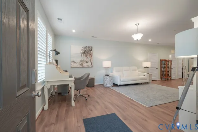 a living room with furniture and a wooden floor
