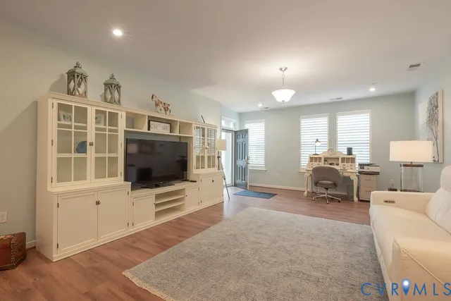 a living room with furniture a flat screen tv and a large window