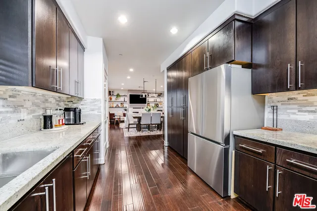 a kitchen with kitchen island granite countertop appliances cabinets and a sink
