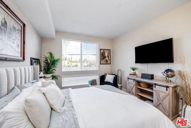 a bedroom with a bed and a flat screen tv