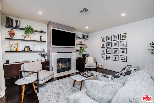 a living room with furniture a flat screen tv and a fireplace