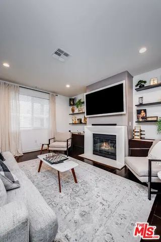 a living room with furniture a fireplace and a flat screen tv