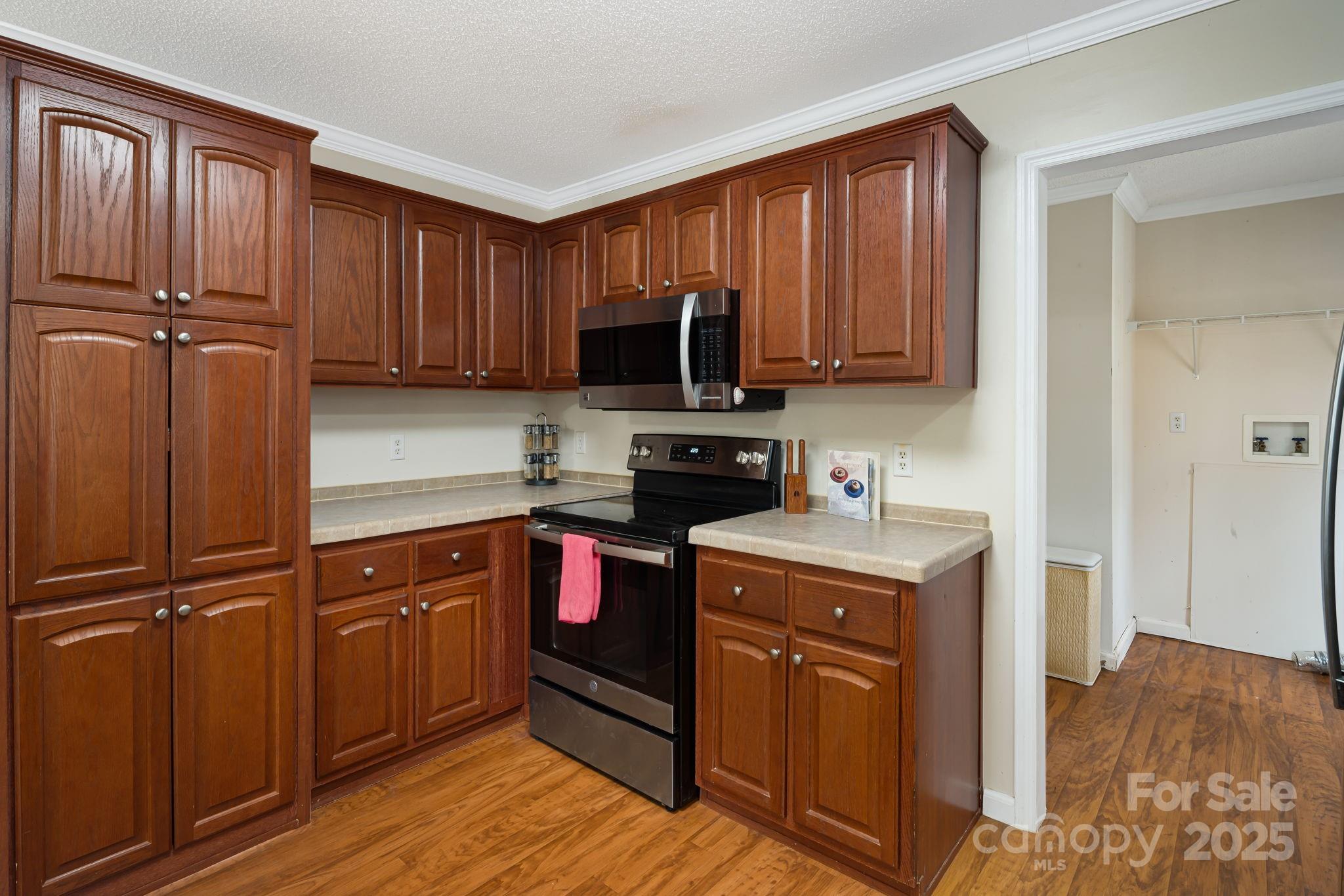 686 Sam Jones Road Burnsville, NC 28714 - Photo 13 of 41 a kitchen with stainless steel appliances granite countertop a stove top oven a sink dishwasher and a refrigerator with wooden floor