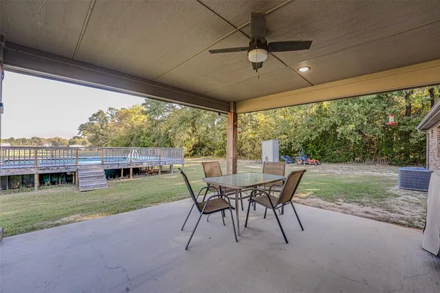 a view of a patio with a table chairs and a yard