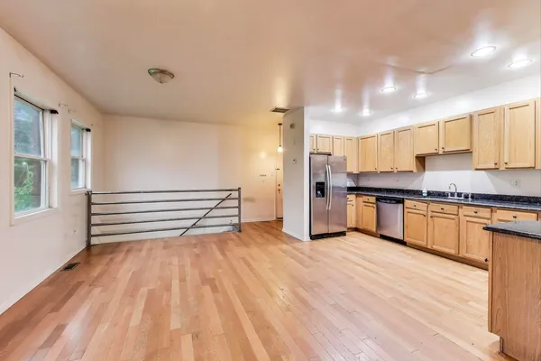 a kitchen with granite countertop a refrigerator and a sink