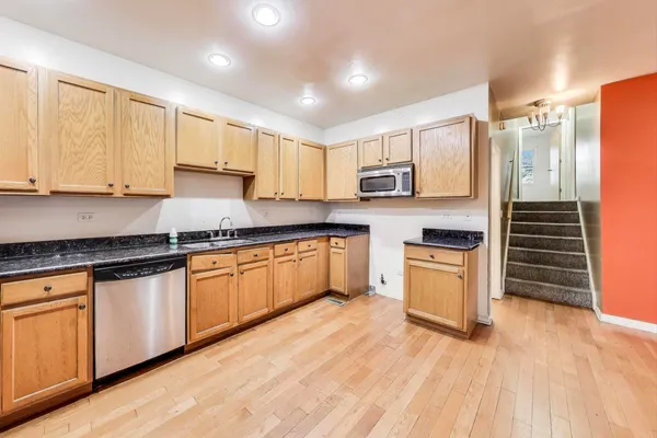 a kitchen with stainless steel appliances granite countertop a stove a sink dishwasher and a refrigerator