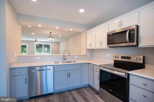 a kitchen with stainless steel appliances granite countertop a sink a stove a microwave and cabinets