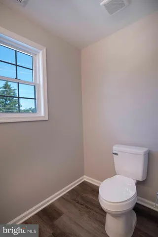 a white toilet sitting next to a window