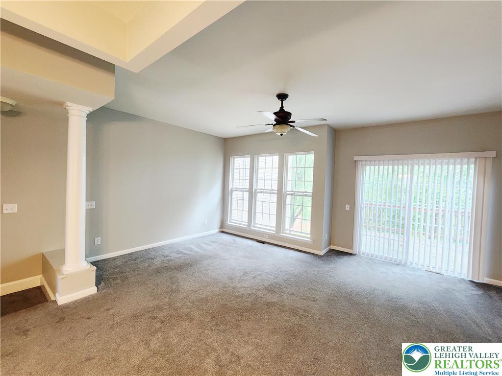 8513 Gateway Road Breinigsville, PA 18031 - Photo 14 of 45 A comfortable living space featuring carpet flooring and abundant natural light from a wall of windows and sliding glass doors.