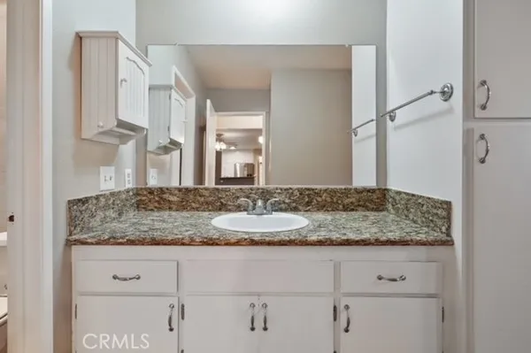 a bathroom with a granite countertop sink and a mirror
