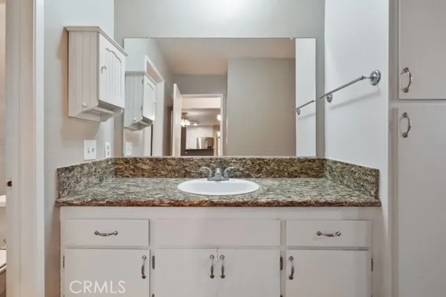 a bathroom with a granite countertop sink and a mirror
