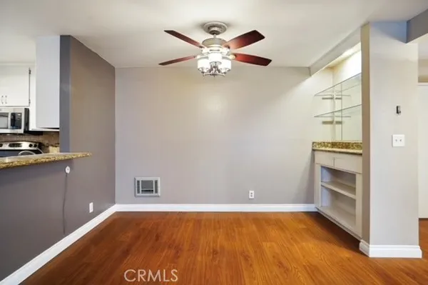 a view of an empty room with window and wooden floor