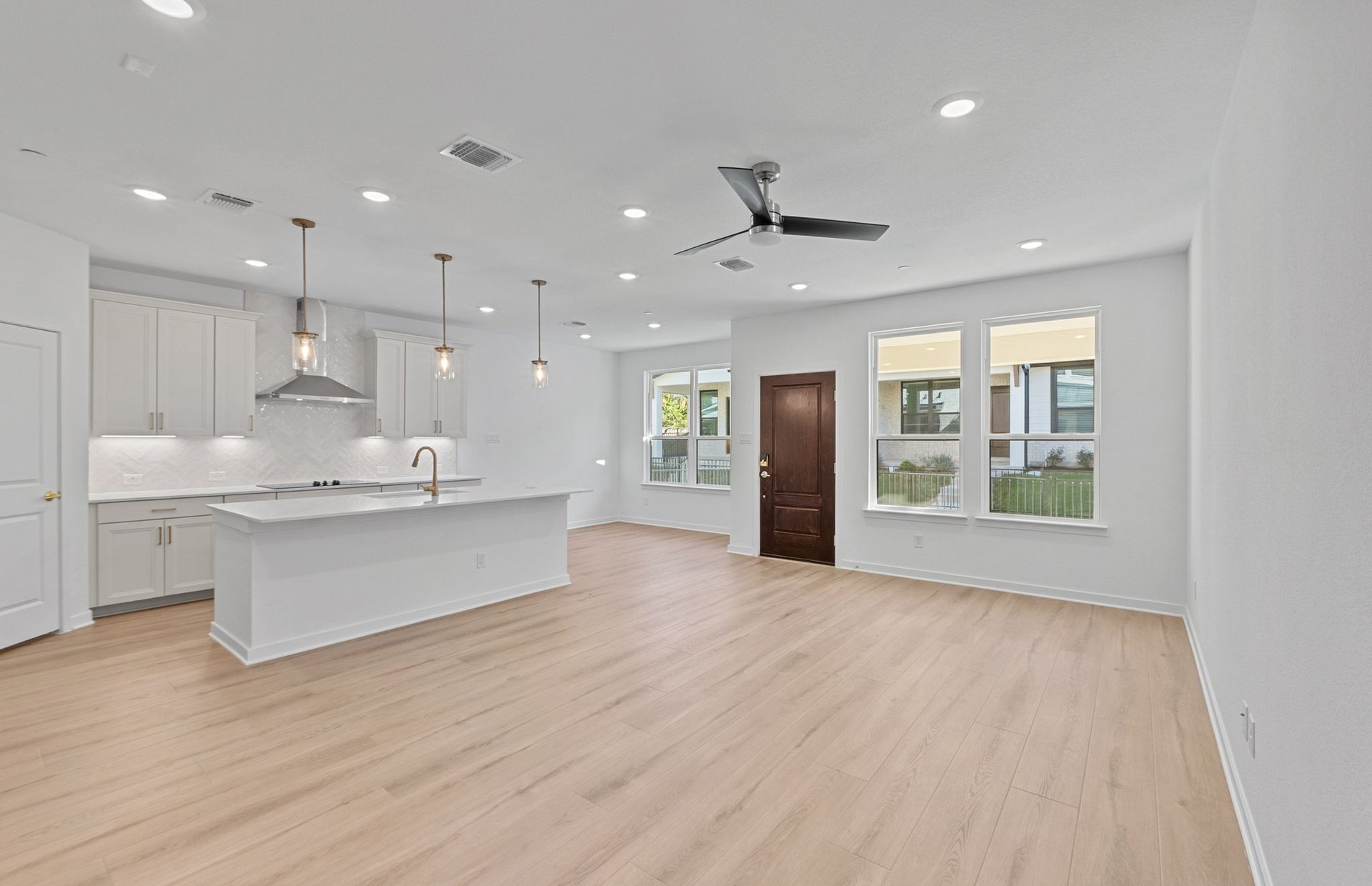 1280 East Main Street, Unit 603 Round Rock, TX 78664 - Photo 5 of 28 a large white kitchen with stainless steel appliances kitchen island a large counter top and a wooden floors