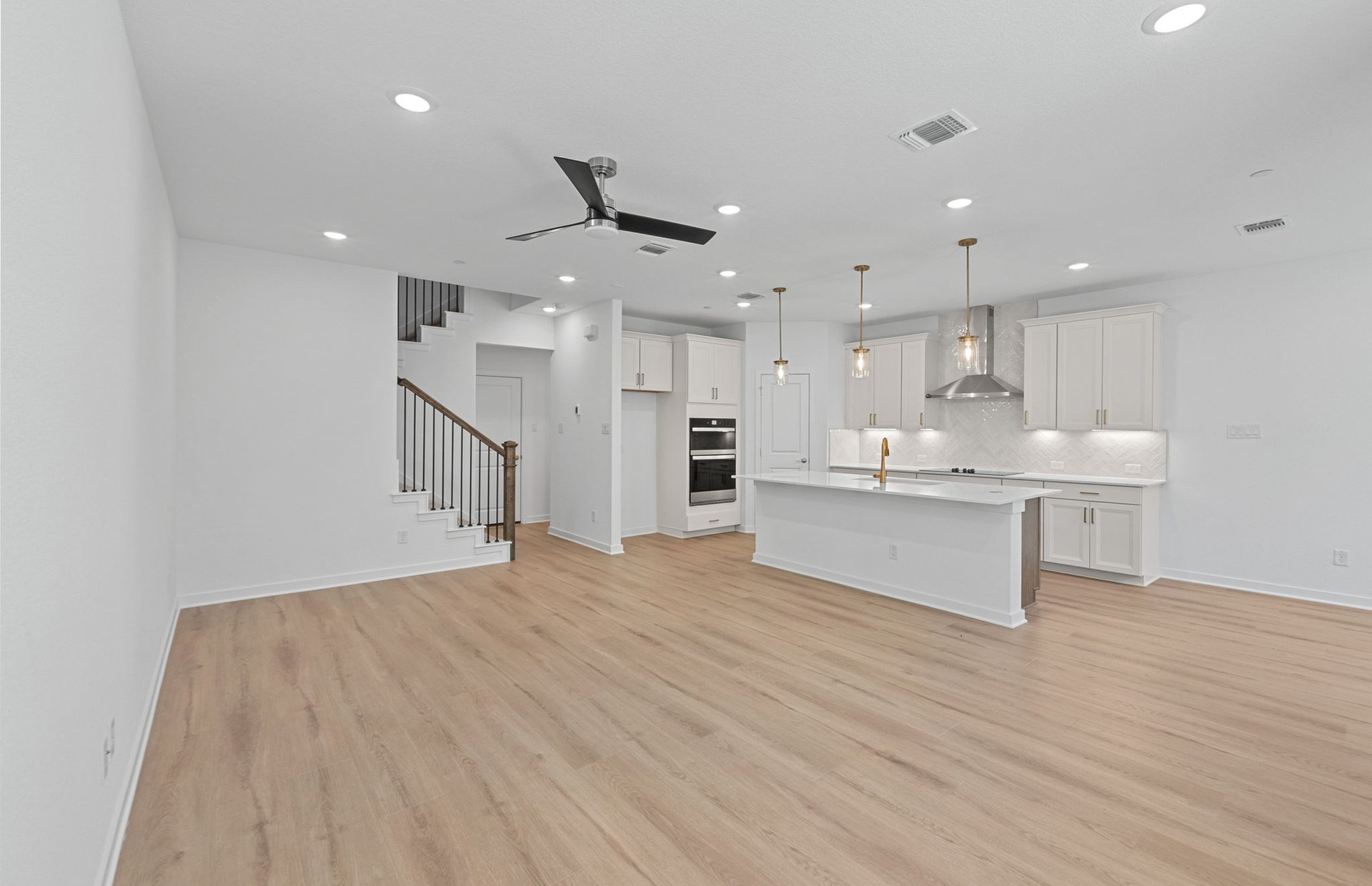 1280 East Main Street, Unit 603 Round Rock, TX 78664 - Photo 7 of 28 a large white kitchen with kitchen island a sink stainless steel appliances and cabinets