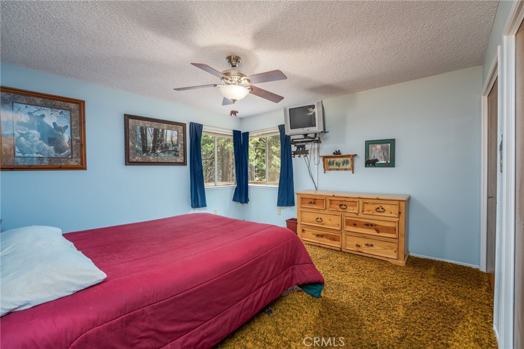 7663 Forest Drive Fish Camp, CA 93623 - Photo 13 of 43 a bed room with a bed and a dresser