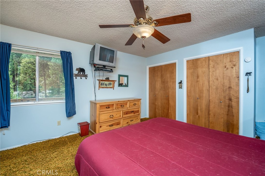 7663 Forest Drive Fish Camp, CA 93623 - Photo 14 of 43 a bedroom with a bed dresser and a window