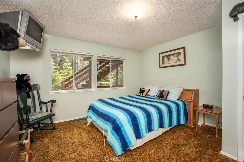 7663 Forest Drive Fish Camp, CA 93623 - Photo 15 of 43 a bedroom with a bed a window and painting on the wall