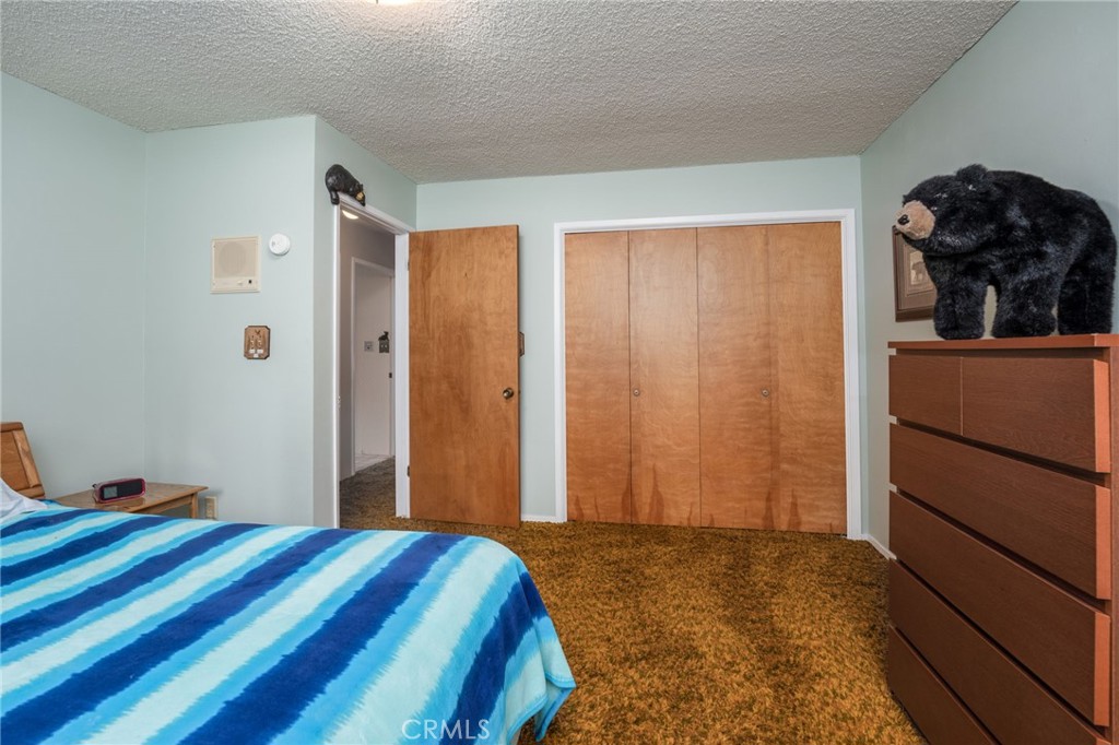 7663 Forest Drive Fish Camp, CA 93623 - Photo 16 of 43 a bedroom with a bed and cabinets