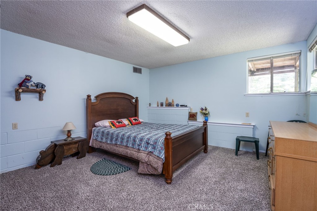 7663 Forest Drive Fish Camp, CA 93623 - Photo 19 of 43 a bedroom with a bed and a window