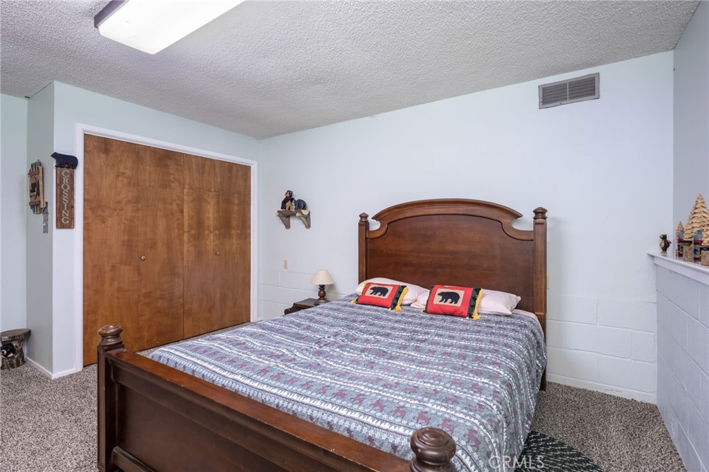 7663 Forest Drive Fish Camp, CA 93623 - Photo 20 of 43 a bedroom with a bed and a dresser