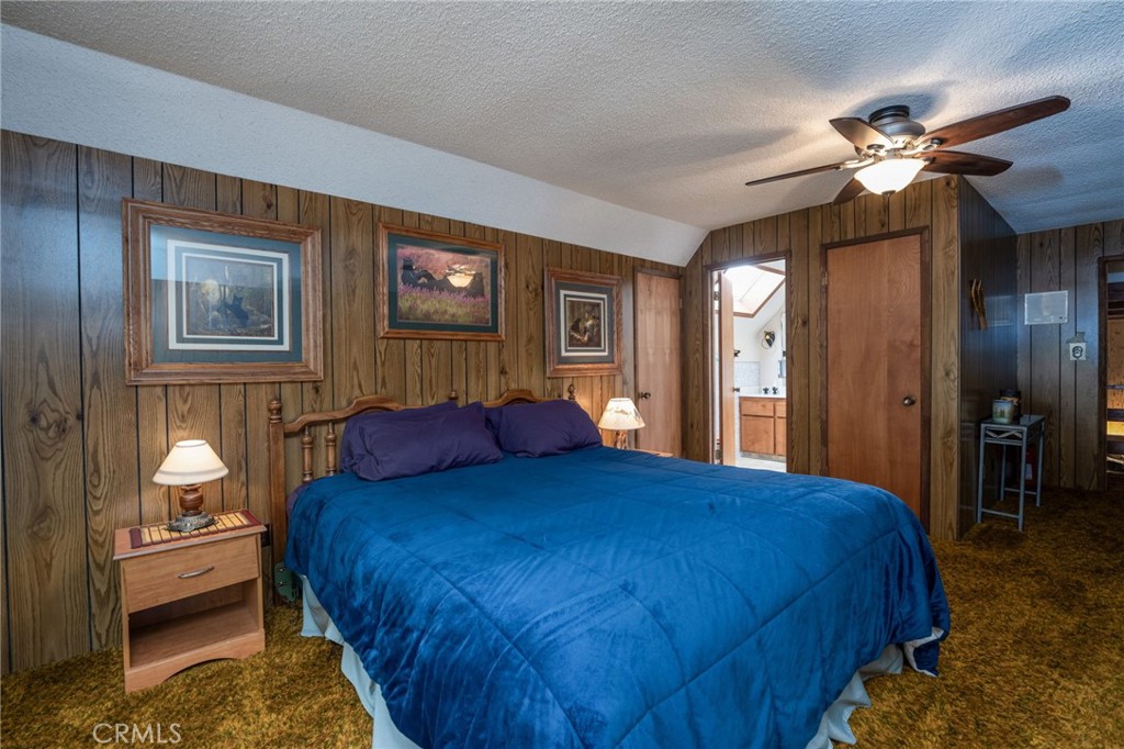 7663 Forest Drive Fish Camp, CA 93623 - Photo 23 of 43 a bedroom with a bed and a chandelier