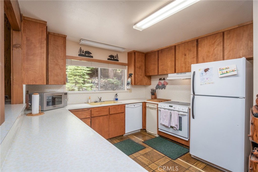 7663 Forest Drive Fish Camp, CA 93623 - Photo 10 of 43 a kitchen with a refrigerator a sink and cabinets