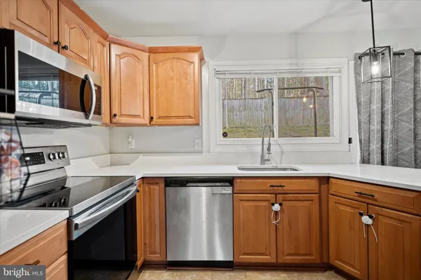 a kitchen with stainless steel appliances granite countertop a sink stove and cabinets