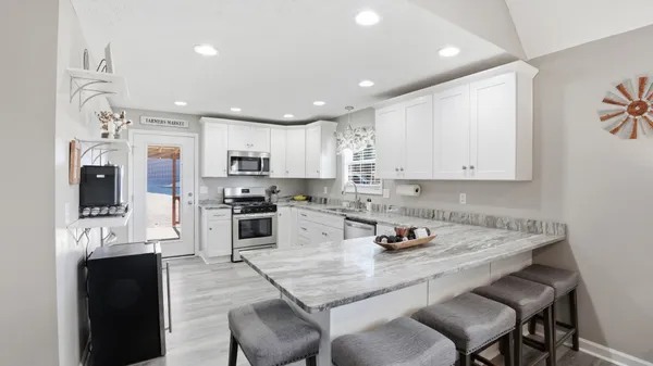a kitchen with cabinets appliances a sink and a window