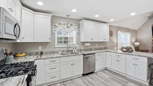 a kitchen with stainless steel appliances a refrigerator cabinets and wooden floor