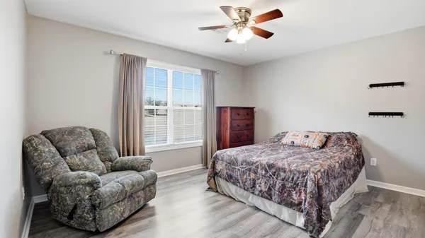 a bedroom with a bed couches and view of kitchen