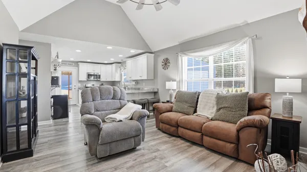a living room with furniture and a view of kitchen