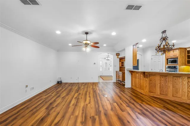 a view of a room with wooden floor and a ceiling fan