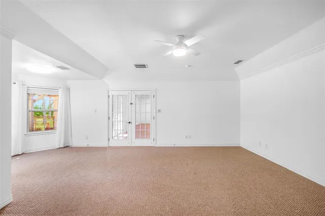 an empty room with windows and fan