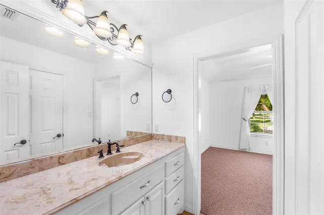 a bathroom with a granite countertop sink a vanity and a mirror