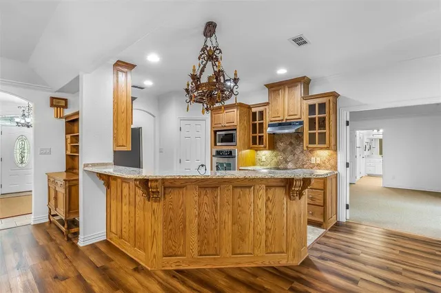 a kitchen with stainless steel appliances granite countertop a sink and a refrigerator
