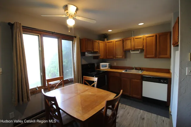 a kitchen with a dining table chairs and refrigerator