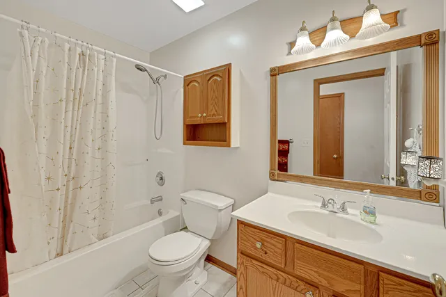 a bathroom with a granite countertop toilet a sink and a mirror