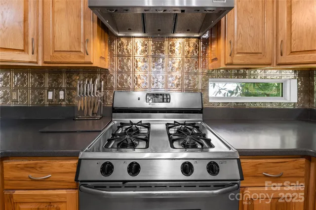 a kitchen with stainless steel appliances granite countertop a sink a stove and a microwave