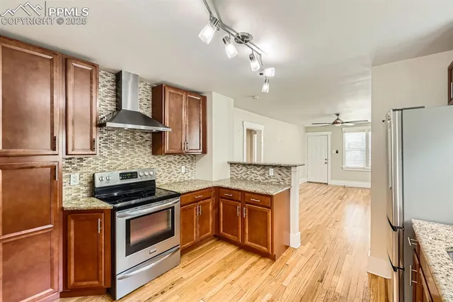 a kitchen with stainless steel appliances granite countertop a sink stove and refrigerator