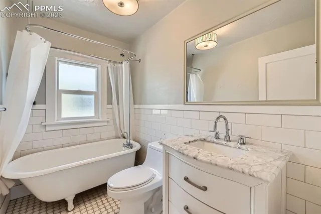 a bathroom with a granite countertop toilet a sink and a bathtub