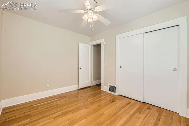 a view of an empty room with wooden floor