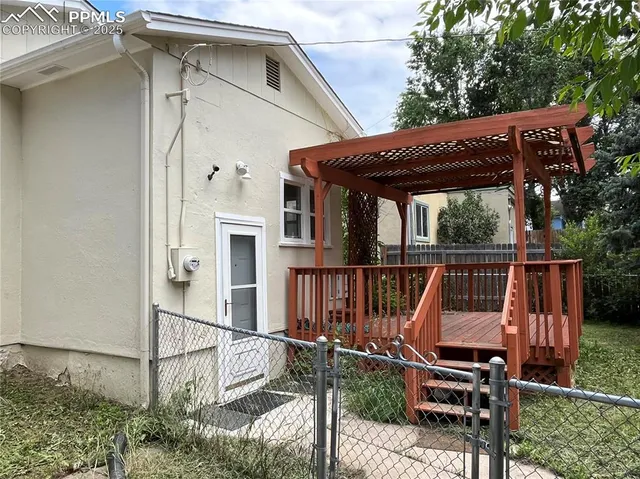 a view of a patio with table and chairs with wooden floor and fence