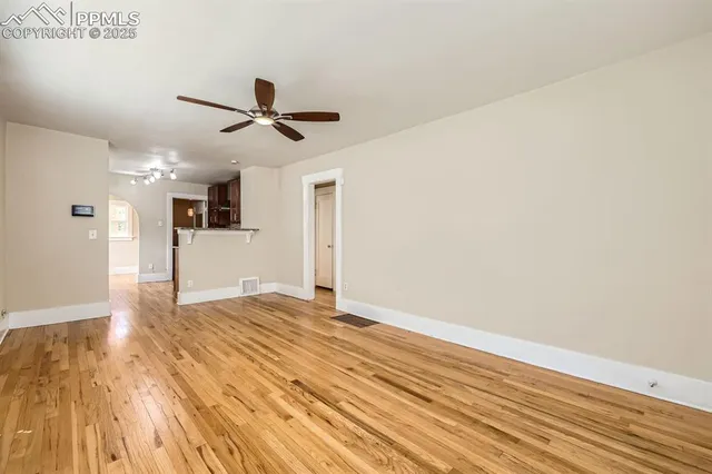 a view of empty room with wooden floor